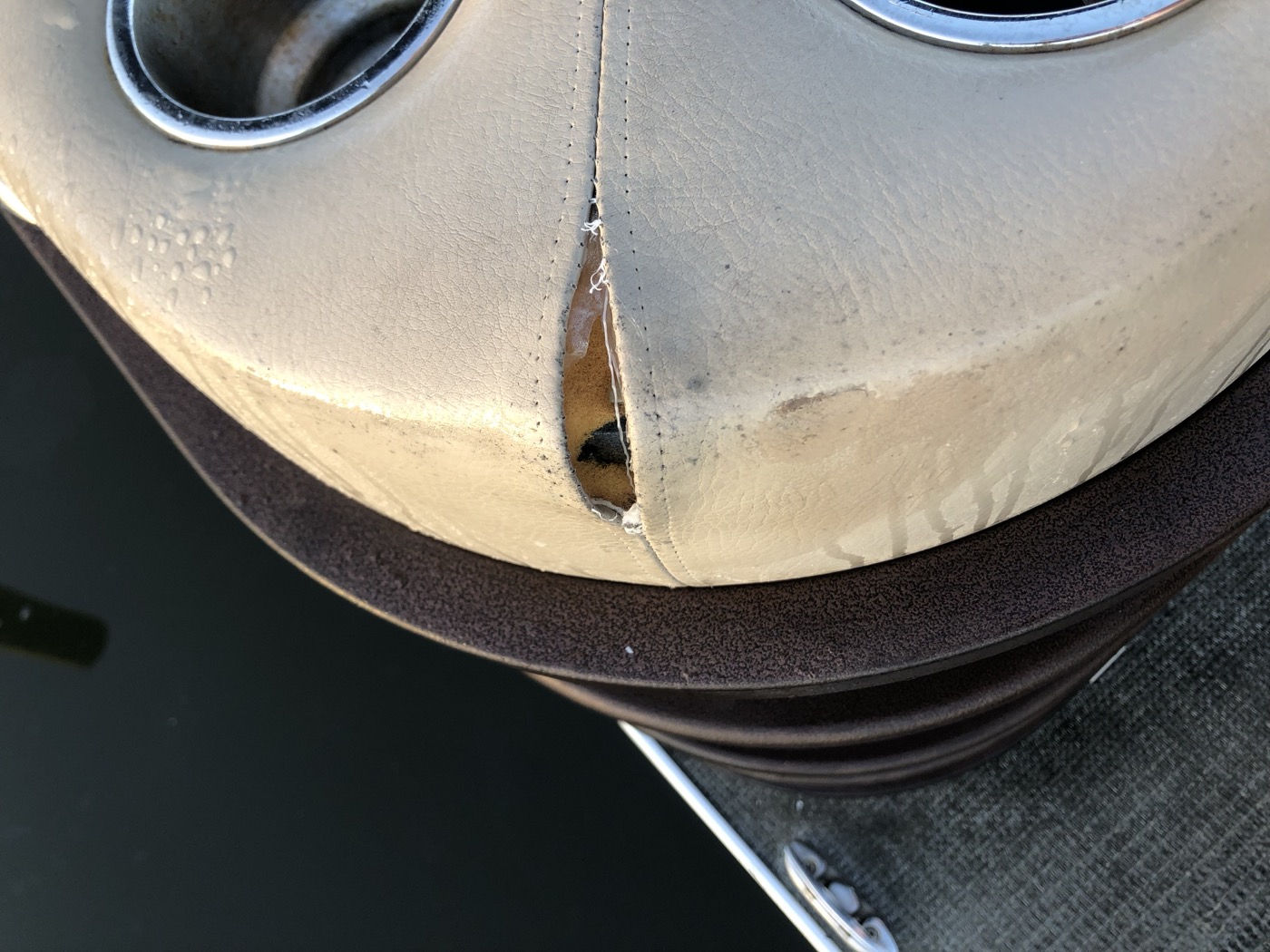 Upholstery torn open next to the cup holders