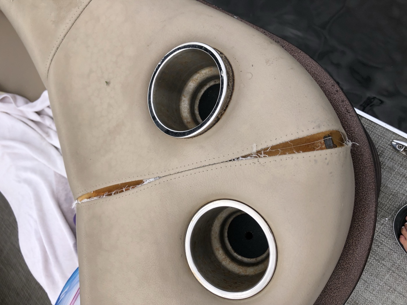Console upholstery torn between the cup holders
